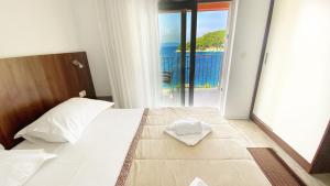 a bedroom with a bed with a view of the ocean at Villa Stina Drvenik in Drvenik
