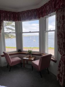 a room with two chairs and a couch and two windows at Ronebhal Guest House in Oban