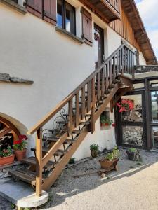 Una escalera de madera fuera de una casa con plantas en macetas. en La Boissellerie, en Saulxures-sur-Moselotte