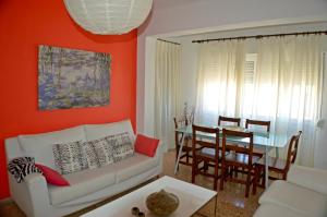 Apartamentos de las Heras في مدينة إيبيزا: غرفة معيشة مع أريكة بيضاء وطاولة