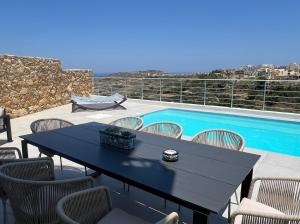 a black table and chairs next to a swimming pool at Summer Getaway 3Bed,Private Pool in Xagħra