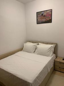 a bed with white sheets and pillows in a bedroom at Secret Villa in Vlorë