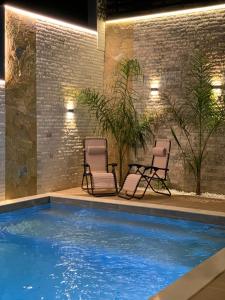 two chairs and a swimming pool in a building at Secret Villa in Vlorë +43 photos