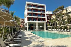 a hotel with a swimming pool with chairs and umbrellas at Savotel in Golem