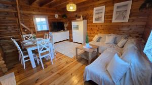 a room with a bed and a table in a cabin at Domek Wałowa 21 in Rewa