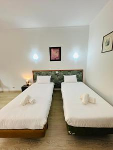 two beds in a room with white sheets at Residencial Pimenta ,Portimao,Algarve in Portimão