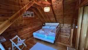 a room with a bed in a log cabin at Domek Wałowa 21 in Rewa