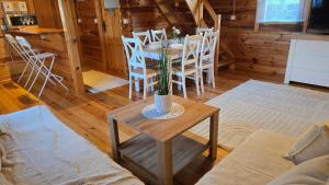 a dining room with a table and chairs in a cabin at Domek Wałowa 21 in Rewa +4 photos
