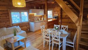 a dining room and kitchen in a log cabin at Domek Wałowa 21 in Rewa