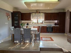 a kitchen with a table and chairs in a room at Casa Maria Tsampika-Spacious Home with 2 Bathrooms & Free Parking in Psinthos
