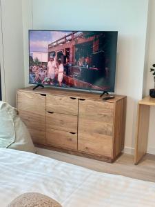 TV de pantalla plana en la parte superior de una cómoda de madera en Concept JJ Luxury Apartments, en Varsovia