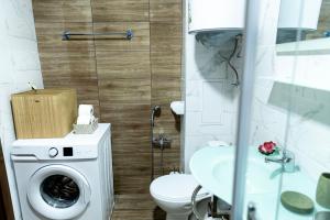 Family Suite One-Bedroom with Kitchen في ساينت قسطنطين وهيلينا: حمام مع مرحاض وغسالة ملابس