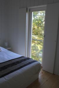 ein Schlafzimmer mit einem Bett und einem großen Fenster in der Unterkunft Moinhos da Corga in Antigo