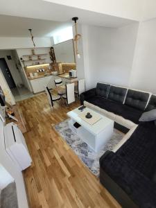 a living room with a black couch and a table at BOHO Apartment- STRUGA in Struga