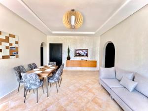 a living room with a table and chairs and a couch at Soft Elegance - Lylac's Garden in Cabo Negro