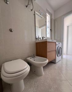 Un baño con un inodoro blanco y un lavabo. en Stella di Mare, en Torre Canne