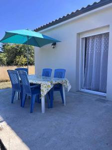 a table and chairs with an umbrella on a patio at Maison au calme in Douzillac