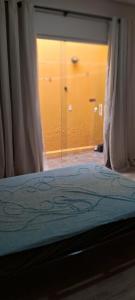 a bedroom with a bed with a window and a closet at Casa Amarela in Itapetininga