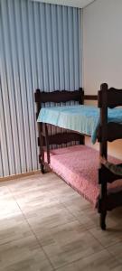 two bunk beds in a room with a window at Casa Amarela in Itapetininga