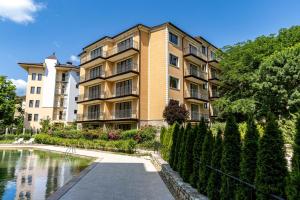 Family Suite One-Bedroom with Kitchen في ساينت قسطنطين وهيلينا: مبنى شقق وامامه بركه