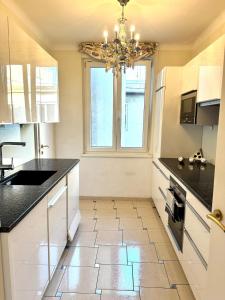a kitchen with black counter tops and a chandelier at Central View Vienna 92 sq m 3 BD apartment in Vienna
