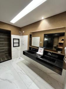 a bathroom with a large mirror and a sink at Mais Hotel in Água Boa