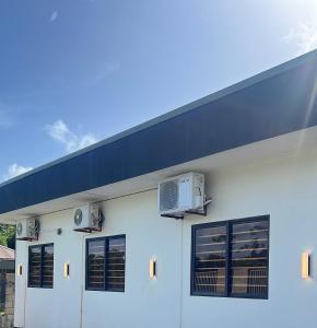 a white building with a blue roof at ELY'S Appartment #1 in Paramaribo