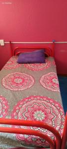 a red bed with a blue pillow on top of it at Posada Doña Mari Aeropuerto in Mexico City