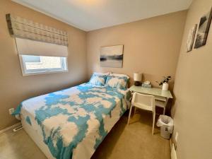 a small bedroom with a bed and a table at Saskatoon Lashyn Cove Homestay in Saskatoon