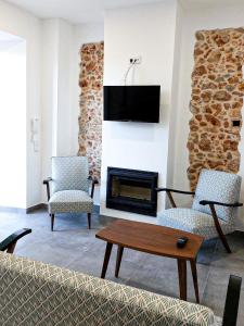 Una sala de estar con dos sillas y una chimenea. en Cosy Country House, en Cerro da Cova