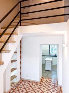 Una escalera en una sala de estar con paredes blancas y barandilla de madera. en Cosy Country House, en Cerro da Cova