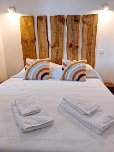 Una cama blanca con dos toallas encima. en Cosy Country House, en Cerro da Cova 115 fotos más