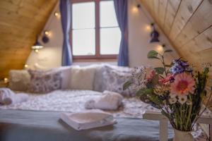 Zimmer mit einem Bett und einer Blumenvase auf dem Tisch in der Unterkunft Chillinn Bikavér Cottage Eger in Eger