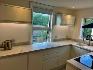 a kitchen with white cabinets and a large window at Central 3 bedroom apartment with superking and king beds in Bognor Regis