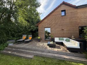 a patio with a couch and chairs on a wooden deck at Küstenglück in Varel