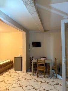 a room with a table and chairs and a television at Horizon in Ureki