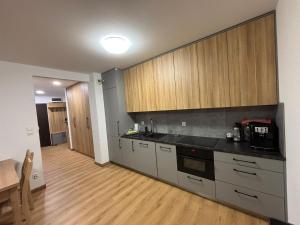 a kitchen with stainless steel appliances and wooden cabinets at Oława Magazynowa in Oława