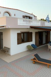 a large white house with a patio and a deck at Casa Maria Tsampika in Psinthos