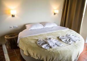 a bedroom with a bed with towels on it at Kallisti Hotel in Potos