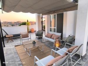 eine Terrasse mit Stühlen und Tischen auf dem Balkon in der Unterkunft POWER HOME in Granada