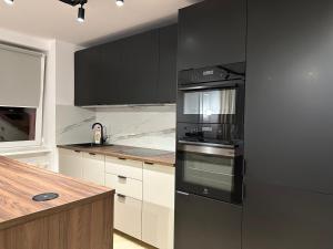 a kitchen with a black refrigerator and a counter at MIO Apartament Sosnowiec in Sosnowiec