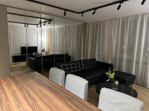 salon ze stołem i czarną kanapą w obiekcie MIO Apartament Sosnowiec w mieście Sosnowiec