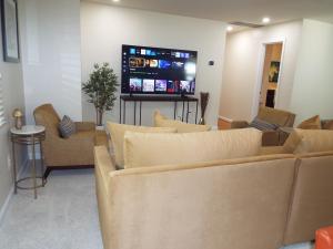 a living room with couches and a flat screen tv at 9 Bedroom 6 Bath - Entire House in Alexandria