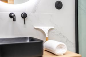 a bathroom sink and a roll of toilet paper next to a mirror at Studio cosy I Centre historique in Cavaillon +16 photos