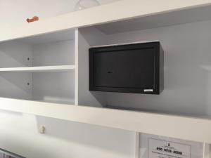 a flat screen tv on a shelf in a room at Horizon Views - Excellent location with ocean view in Puerto Rico de Gran Canaria