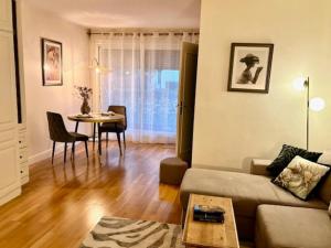 a living room with a couch and a table at L'écrin du 12- Studio élégant sur jardin avec parking in Paris