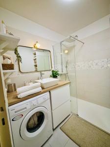 a bathroom with a washing machine and a sink at L'écrin du 12- Studio élégant sur jardin avec parking in Paris