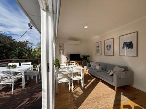 a living room with a couch and a table at Sunrise on the Water in Lemon Tree Passage