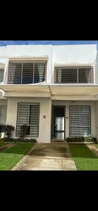 a white house with shuttered windows and a driveway at Casa Vallarta in Jarretadera