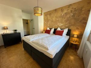 a bedroom with a large bed with red pillows at Black Suite 13 - Design-Apartment in Bad Krozingen